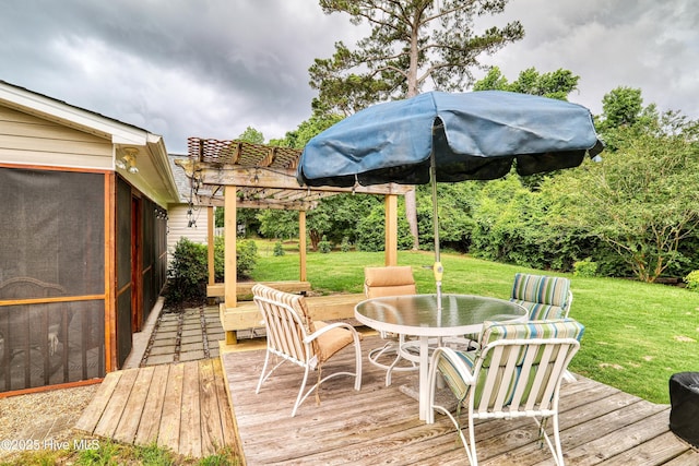 wooden deck featuring outdoor dining space and a yard