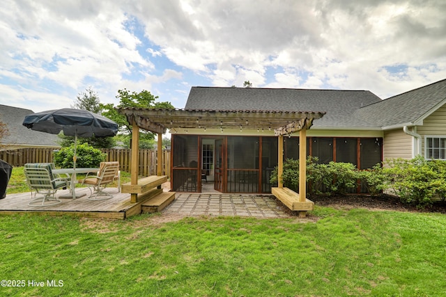 rear view of property with a pergola, a deck, a sunroom, and roof with shingles