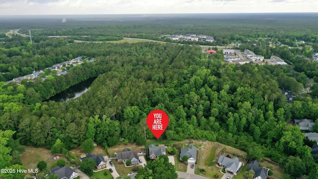 view of property location with a forest and nearby suburban area