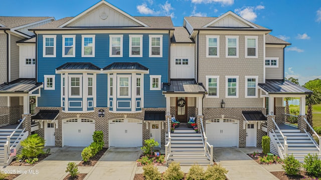 townhome / multi-family property featuring stairs, board and batten siding, a standing seam roof, and driveway