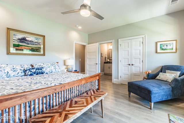 bedroom with light wood-style floors, a closet, ceiling fan, and ensuite bathroom