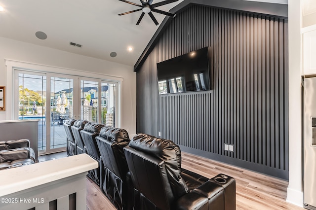 cinema room with vaulted ceiling, light wood-type flooring, ceiling fan, french doors, and recessed lighting
