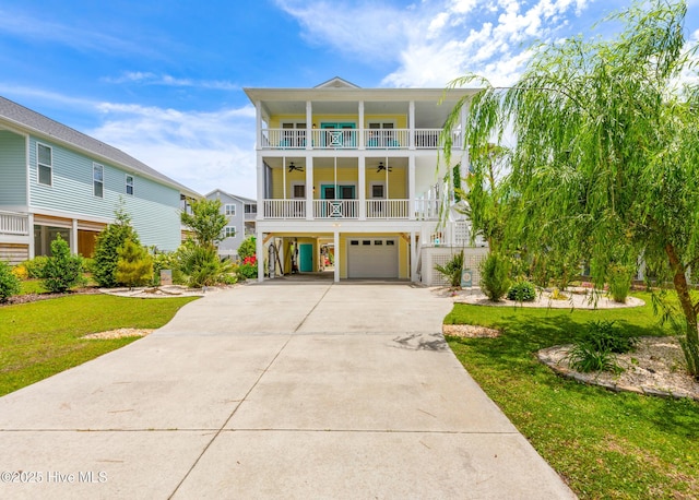 104 SE 32nd St, Oak Island, NC 28465 - coastal home featuring ceiling fan, concrete driveway, a front yard, a garage, and a balcony