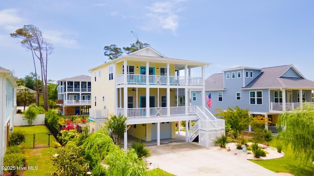 104 SE 32nd St, Oak Island, NC 28465 - back of house featuring a garage, driveway, stairs, fence, and a porch