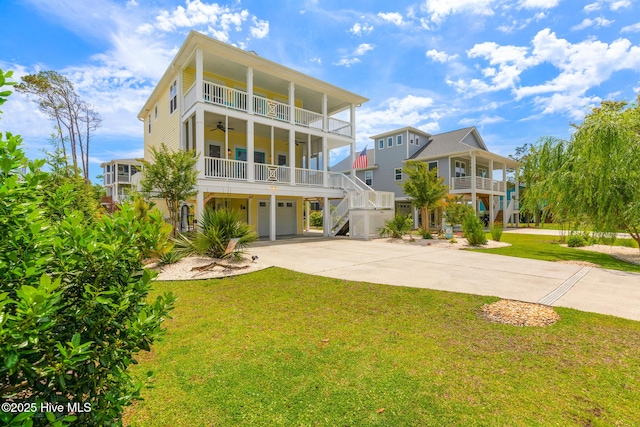104 SE 32nd St, Oak Island, NC 28465 - rear view of property featuring a garage, driveway, a ceiling fan, a yard, and a balcony