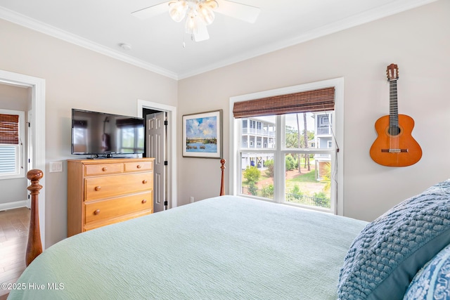 104 SE 32nd St, Oak Island, NC 28465 - bedroom featuring crown molding, multiple windows, wood finished floors, a ceiling fan, and baseboards