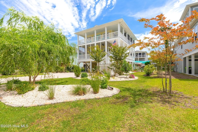 104 SE 32nd St, Oak Island, NC 28465 - back of house with a lawn and a balcony