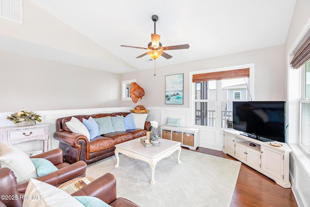 104 SE 32nd St, Oak Island, NC 28465 - living area with lofted ceiling, wood finished floors, a wainscoted wall, ceiling fan, and a decorative wall