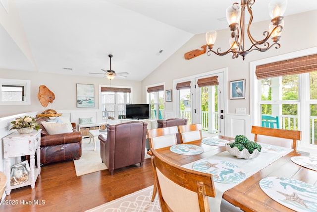 104 SE 32nd St, Oak Island, NC 28465 - dining space with vaulted ceiling, a decorative wall, wood finished floors, wainscoting, and healthy amount of natural light