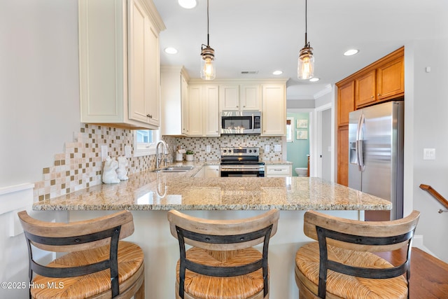 104 SE 32nd St, Oak Island, NC 28465 - kitchen with stainless steel appliances, a sink, a peninsula, tasteful backsplash, and recessed lighting