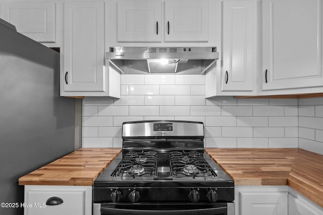 kitchen featuring butcher block counters, black gas stove, under cabinet range hood, and white cabinets