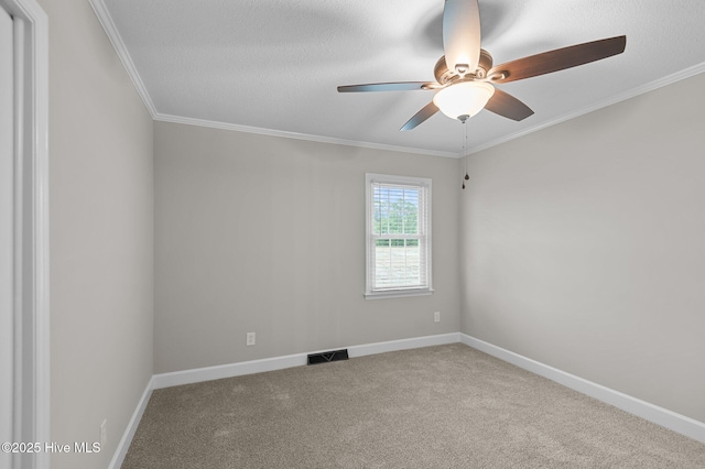spare room with carpet floors, ceiling fan, ornamental molding, and baseboards