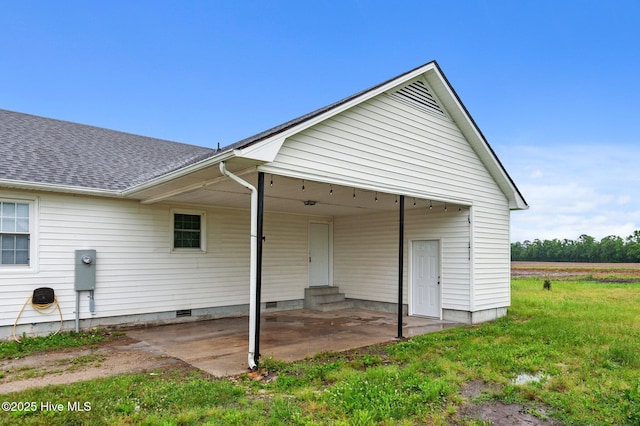 rear view of house featuring entry steps, crawl space, and roof with shingles