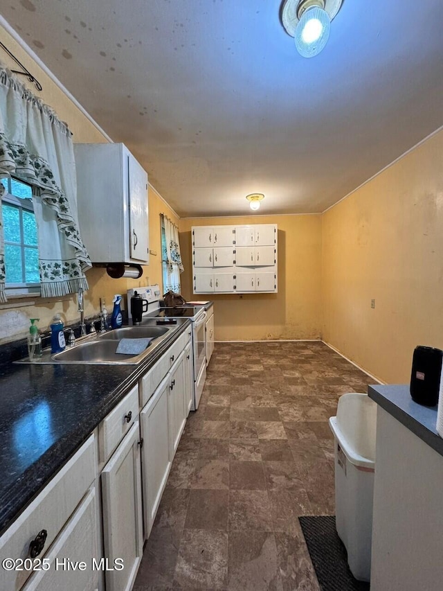 6748 Pitt St, Grifton, NC 28530 - kitchen with white range with electric stovetop, a sink, dark countertops, and white cabinetry