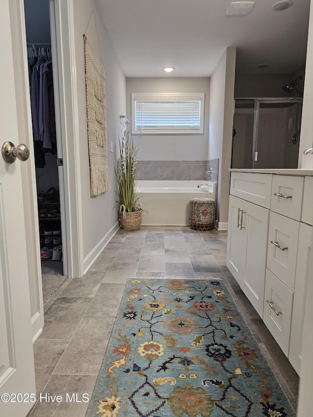 568 Transom Way, Sneads Ferry, NC 28460 - full bathroom with a bath, a shower stall, a spacious closet, baseboards, and tile patterned floors