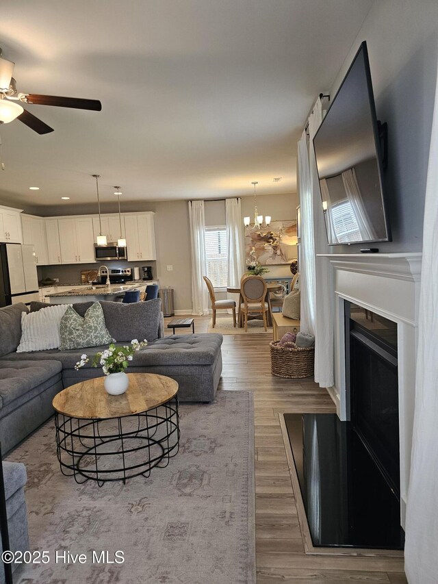 568 Transom Way, Sneads Ferry, NC 28460 - living area with ceiling fan, wood finished floors, a chandelier, recessed lighting, and a fireplace