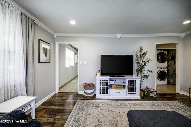 living area with stacked washer and clothes dryer, ornamental molding, wood finished floors, baseboards, and recessed lighting