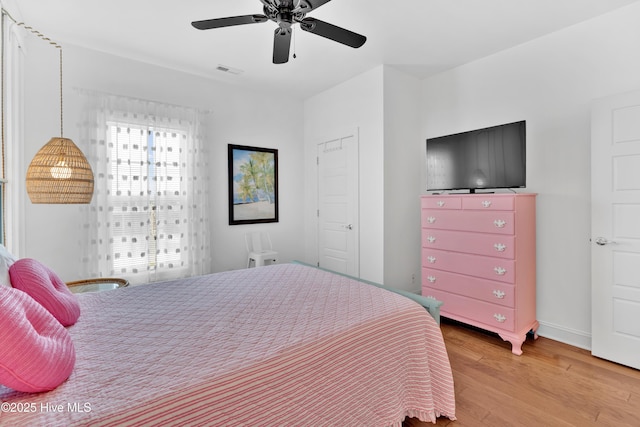 2304 W Dolphin Dr, Oak Island, NC 28465 - bedroom with light wood-style flooring, baseboards, and ceiling fan