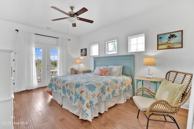 2304 W Dolphin Dr, Oak Island, NC 28465 - bedroom featuring access to exterior, multiple windows, wood finished floors, and a ceiling fan