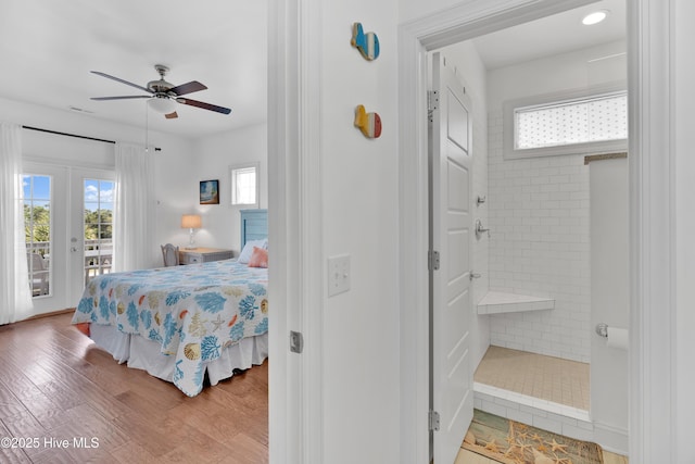 2304 W Dolphin Dr, Oak Island, NC 28465 - bedroom with access to exterior, multiple windows, wood finished floors, and ensuite bathroom