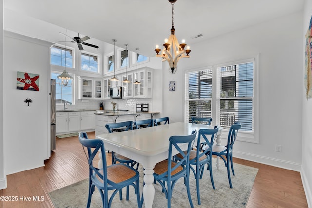 2304 W Dolphin Dr, Oak Island, NC 28465 - dining space featuring a chandelier, plenty of natural light, light wood finished floors, and ceiling fan