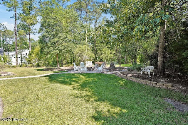 886 Hollybriar Dr SE, Bolivia, NC 28422 - view of green lawn featuring a fire pit and a patio area