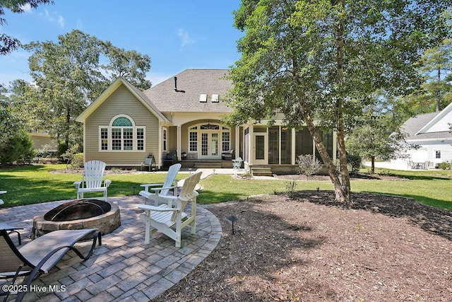 886 Hollybriar Dr SE, Bolivia, NC 28422 - back of house featuring a fire pit, french doors, a patio, a lawn, and a sunroom