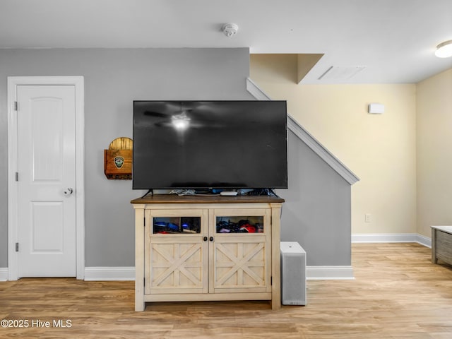 detailed view of a smoke detector, wood finished floors, and baseboards