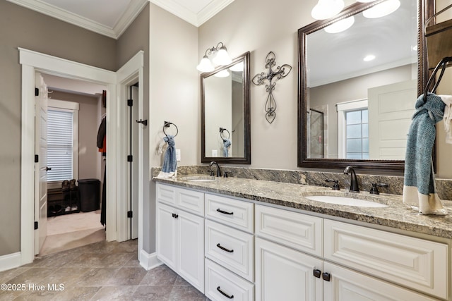 bathroom featuring crown molding, baseboards, and double vanity