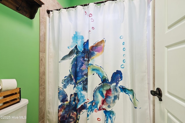 bathroom featuring curtained shower and toilet