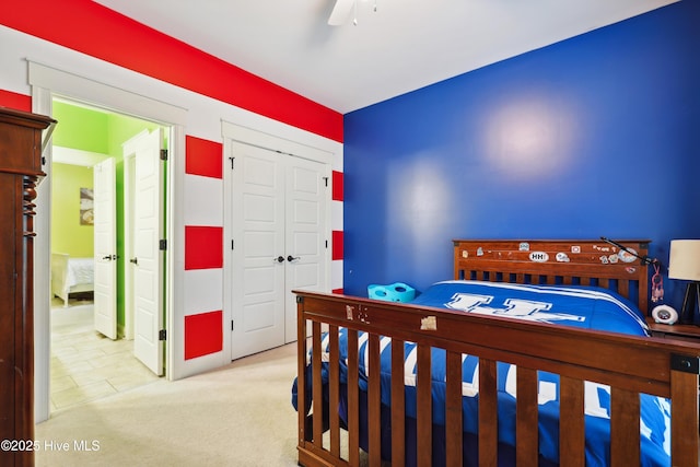 carpeted bedroom featuring a closet and a ceiling fan