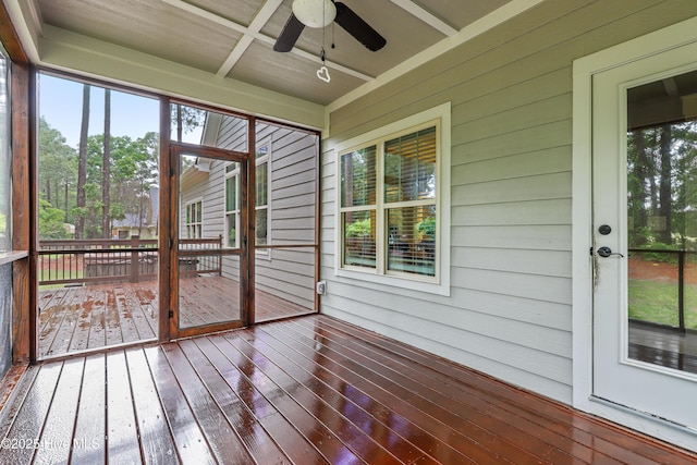 unfurnished sunroom featuring a ceiling fan and french doors