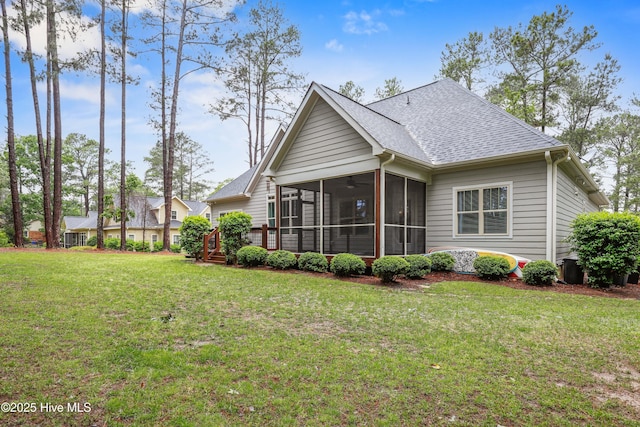 back of house with a sunroom, a yard, and a shingled roof