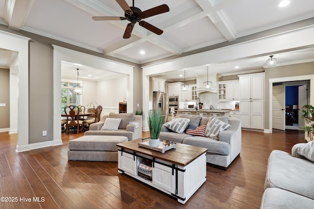 living area with ceiling fan, beamed ceiling, dark wood finished floors, baseboards, and coffered ceiling