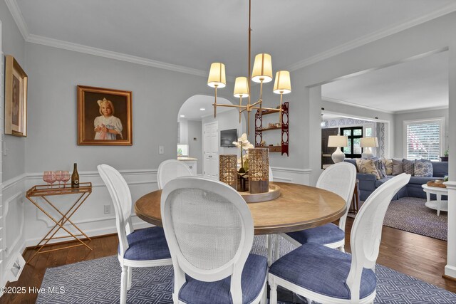 1218 Country Club Rd, Wilmington, NC 28403 - dining area featuring ornamental molding, wood finished floors, arched walkways, wainscoting, and a chandelier