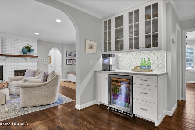 1218 Country Club Rd, Wilmington, NC 28403 - indoor dry bar with beverage cooler, arched walkways, dark wood-style floors, crown molding, and baseboards