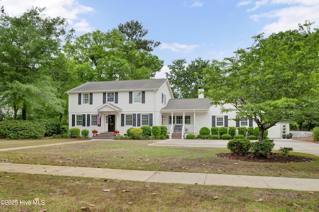 1218 Country Club Rd, Wilmington, NC 28403 - colonial-style house with a chimney, a porch, and a front lawn