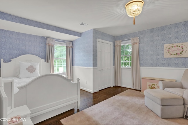 1218 Country Club Rd, Wilmington, NC 28403 - bedroom featuring wood finished floors, wallpapered walls, multiple windows, a chandelier, and wainscoting