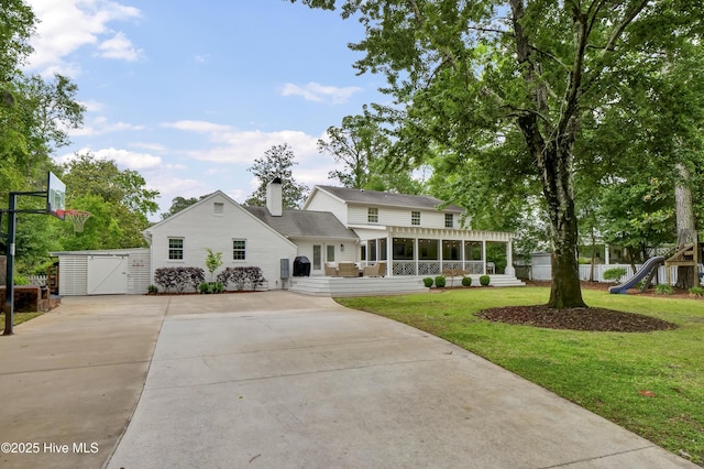 1218 Country Club Rd, Wilmington, NC 28403 - view of front of property featuring a sunroom, concrete driveway, a chimney, and a gate