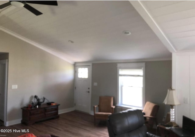 living room featuring a ceiling fan, wood finished floors, ornamental molding, baseboards, and vaulted ceiling