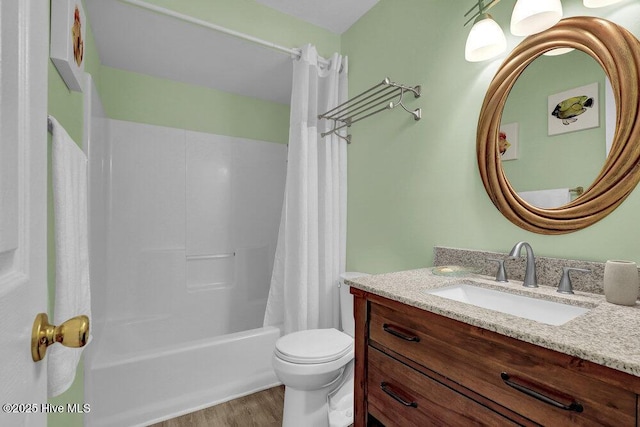 bathroom featuring wood finished floors, vanity, toilet, and shower / tub combo