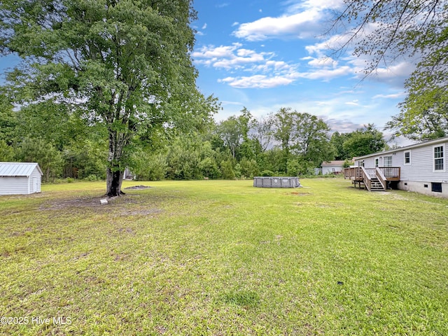 70 Little Pond Rd, Rocky Point, NC 28457 - view of green lawn featuring a wooden deck, a storage shed, an outdoor pool, an outbuilding, and view of scattered trees