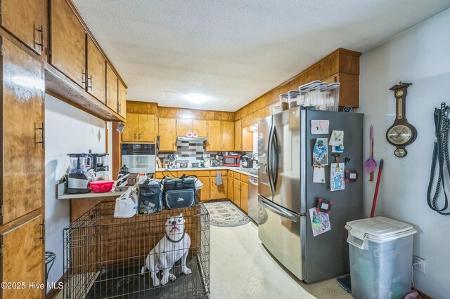 525 Edwards Rd, Jacksonville, NC 28540 - kitchen with stainless steel appliances, brown cabinetry, light countertops, decorative backsplash, and a textured ceiling