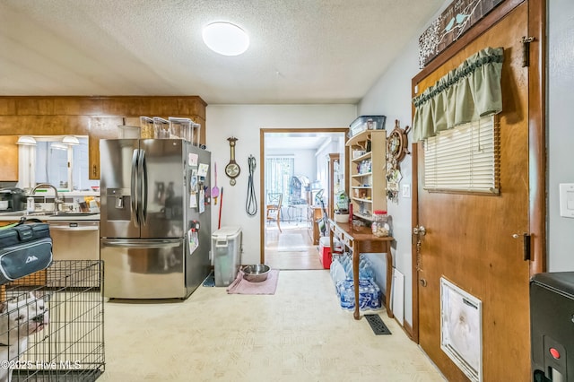 525 Edwards Rd, Jacksonville, NC 28540 - kitchen with stainless steel fridge, a textured ceiling, a sink, and light colored carpet