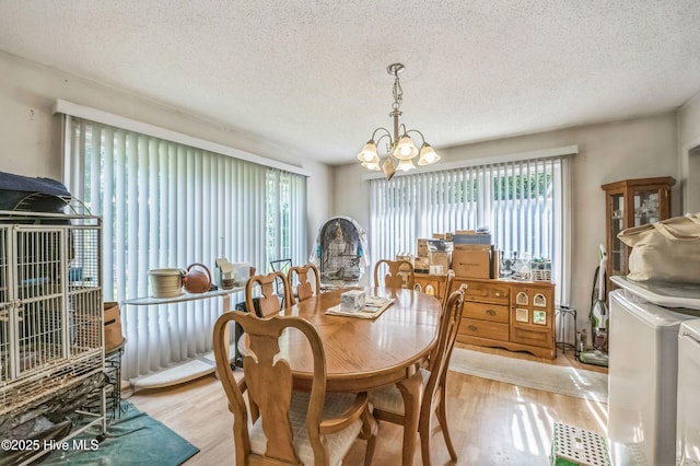 525 Edwards Rd, Jacksonville, NC 28540 - dining area with separate washer and dryer, a chandelier, light wood-style floors, and a textured ceiling