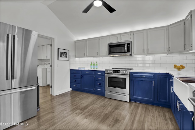 1855 Newkirk Rd, Wilmington, NC 28409 - kitchen with appliances with stainless steel finishes, washing machine and dryer, ceiling fan, vaulted ceiling, and decorative backsplash