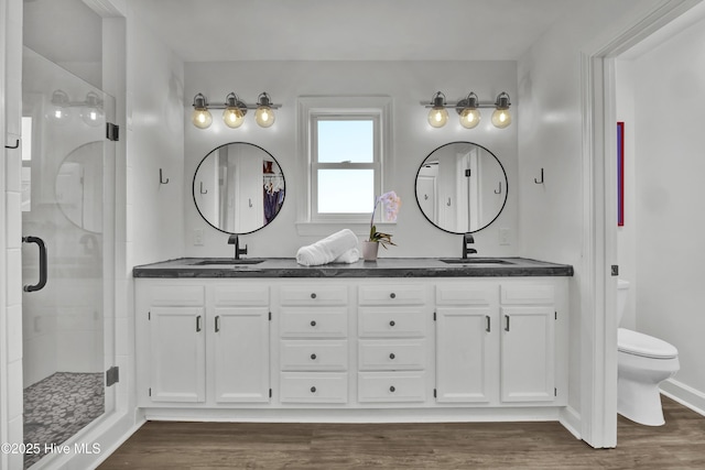 1855 Newkirk Rd, Wilmington, NC 28409 - full bathroom with double vanity, toilet, a shower stall, and wood finished floors