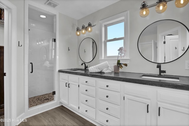 1855 Newkirk Rd, Wilmington, NC 28409 - full bath featuring a stall shower, double vanity, and wood finished floors