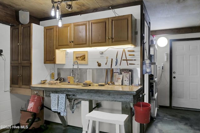 1855 Newkirk Rd, Wilmington, NC 28409 - kitchen featuring a sink, finished concrete floors, a kitchen breakfast bar, and brown cabinets