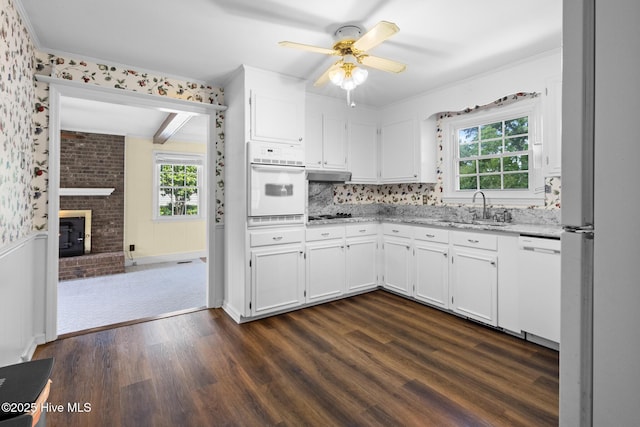 330 Breckenridge Dr, Wilmington, NC 28412 - kitchen featuring white appliances, dark wood-style flooring, healthy amount of natural light, ceiling fan, and wainscoting